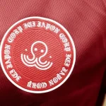 Logo d’Ici Japon Corp Esport brodé sur un maillot rouge