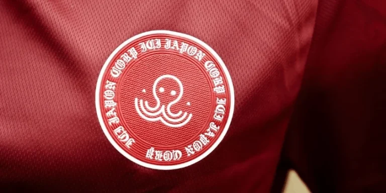 Logo d’Ici Japon Corp Esport brodé sur un maillot rouge